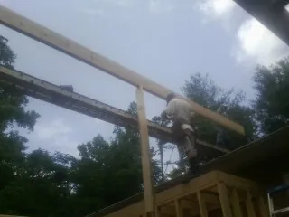 Carpenter setting a ridge beam over a new addition frame — Ice Dam Removal by Roofing Brothers in Glen Arm
