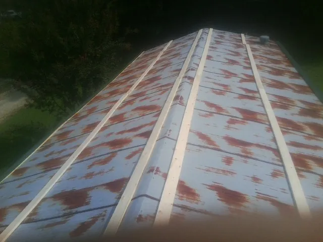Rusted metal roof panels with new wood purlins before replacement — Storm Damage Roof Repair in Glen Arm by Roofing Brothers