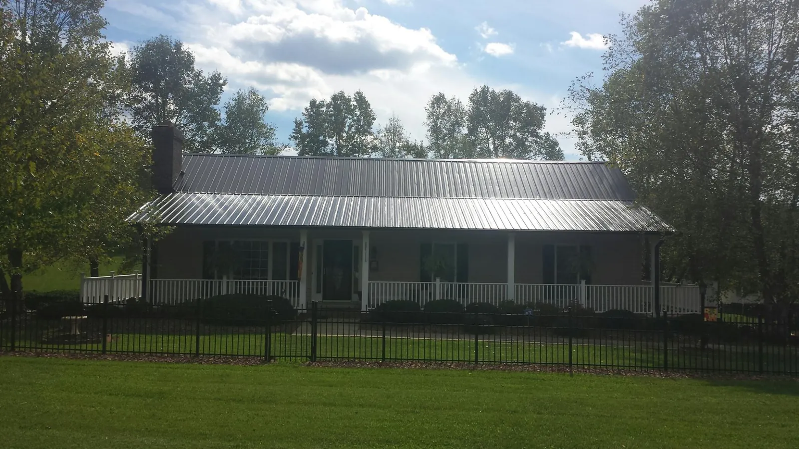 Gray metal roof on a brick ranch with a full width front porch — Gutter Guard Installation work by our crew in Glen Arm