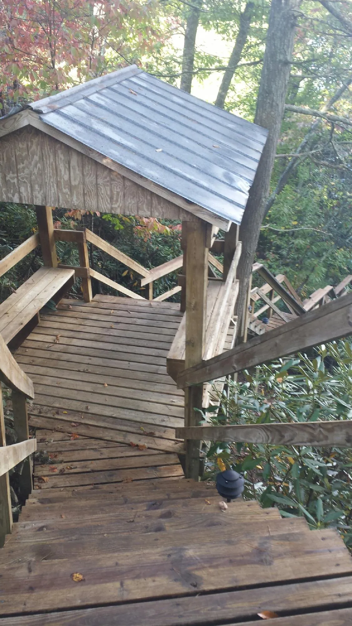 Metal roofed shelter over wooden steps on a wooded walkway — Skylight Repair & Installation work by our crew in Glen Arm