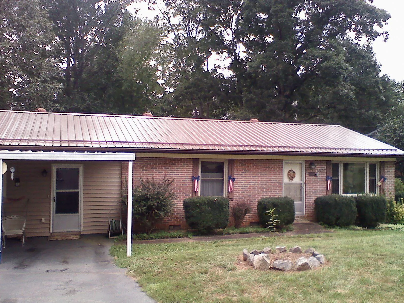 Bronze metal roof and carport on a brick ranch home — Roof Repair work by our crew in Glen Arm